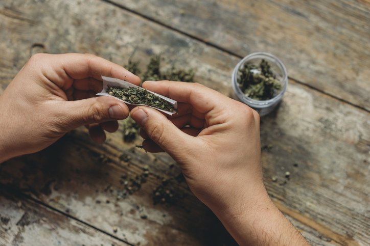 MAN ROLLING A MARIJUANA JOINT
