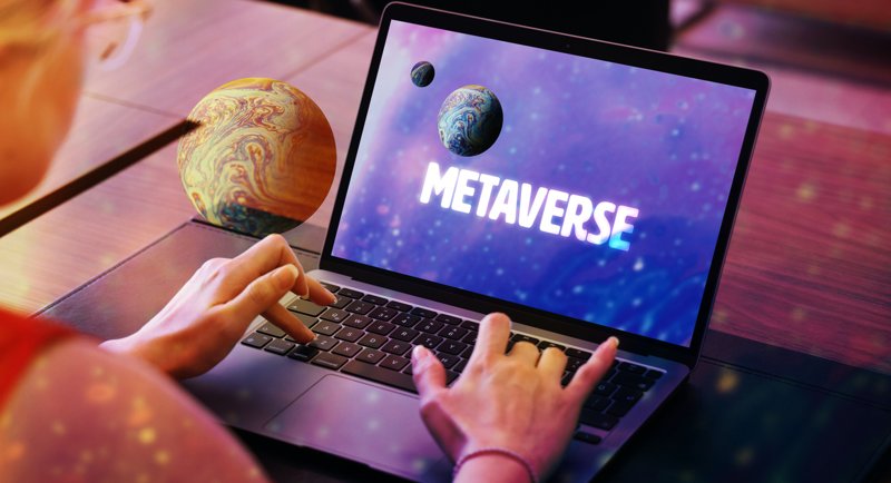 άντρας με ανοιχτο laptop σε οθόνη που γράφει metaverse